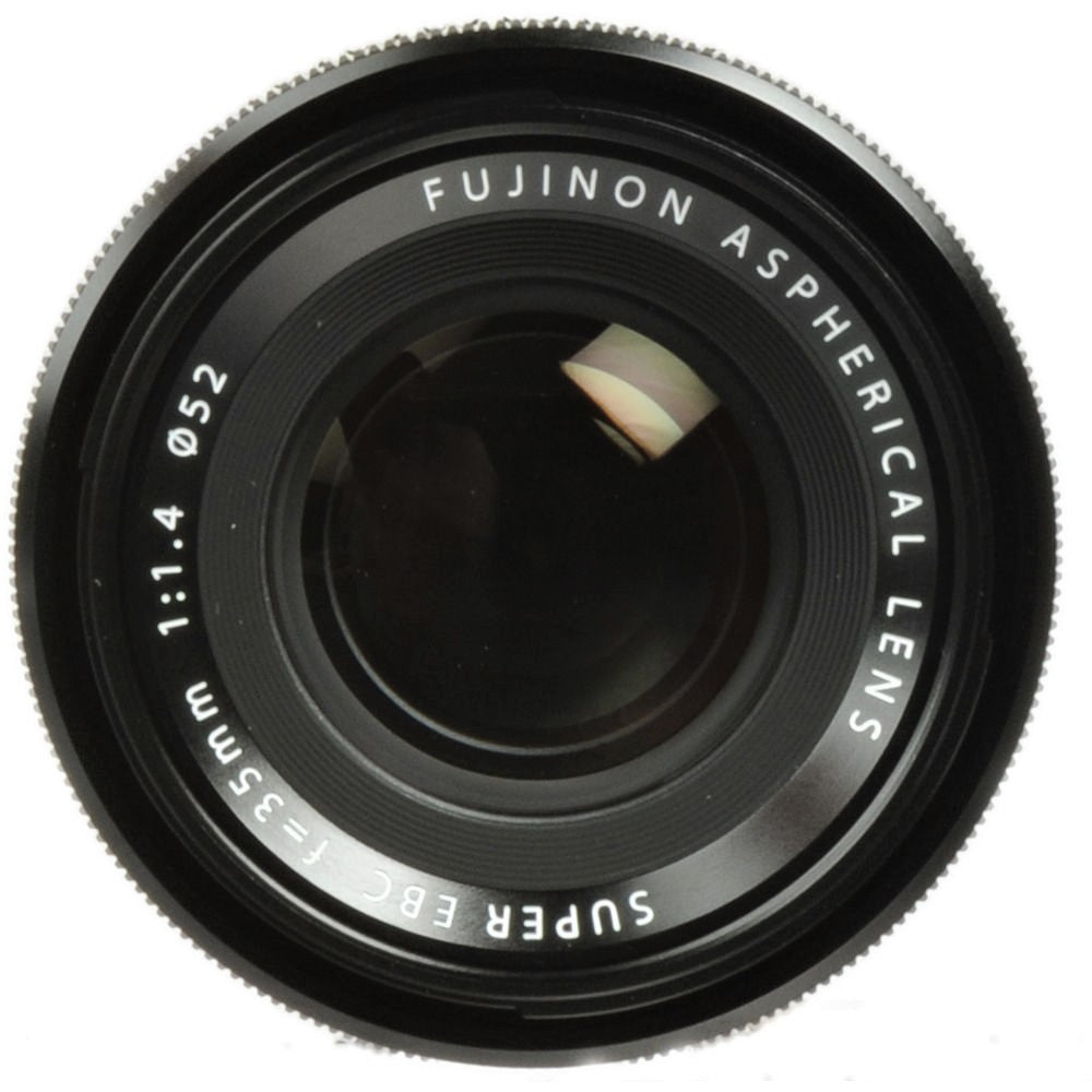 This image displays the front element of the Fujifilm XF 35mm F1.4 R lens. The lens is labeled with "FUJINON ASPHERICAL LENS SUPER EBC f=35mm 1:1.4 ø52" in white text around the front element, which reflects light and shows a partial reflection of the surrounding environment.